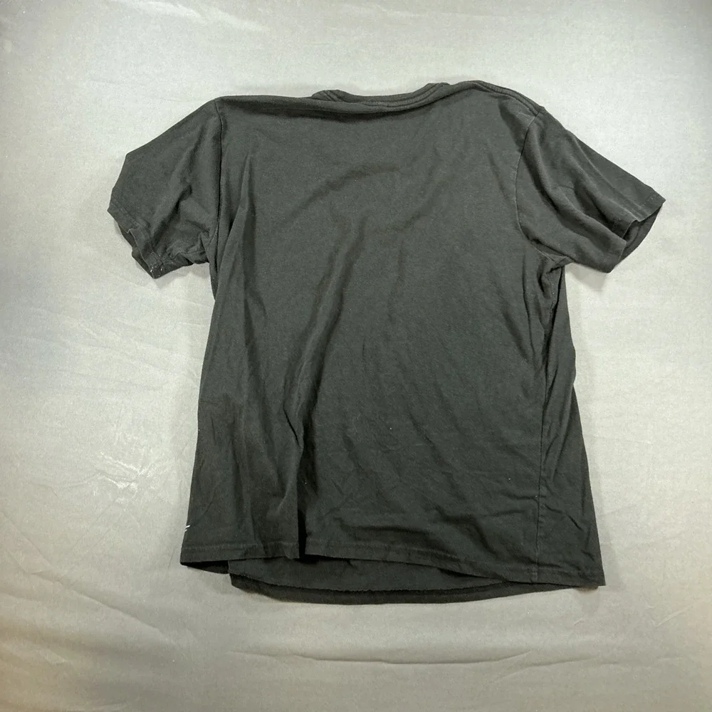 black graphic T-shirt features a central illustration of a woman in a black Sz L